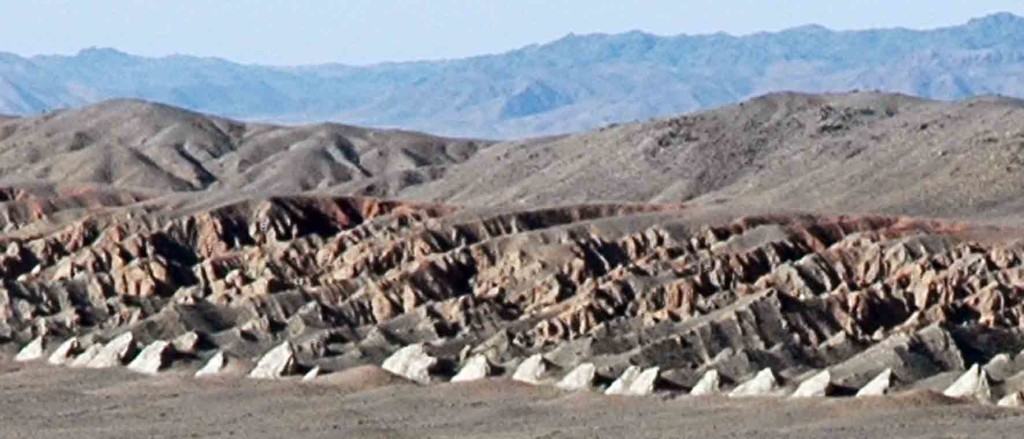 A row of pale 'teeth' along the southern margin of the Khantaishir Mountains, Mongolia. These are up-turned strata that reveal a history of the rise of the Gobi Altai.
