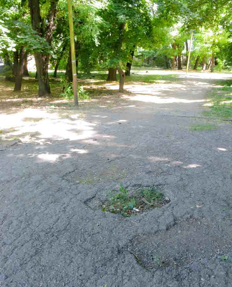 Holes in the park footpath, Taganrog - war graves.