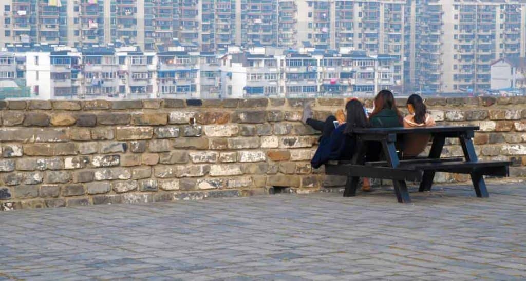 Three friends put their feet up on the Nanjing city wall.
