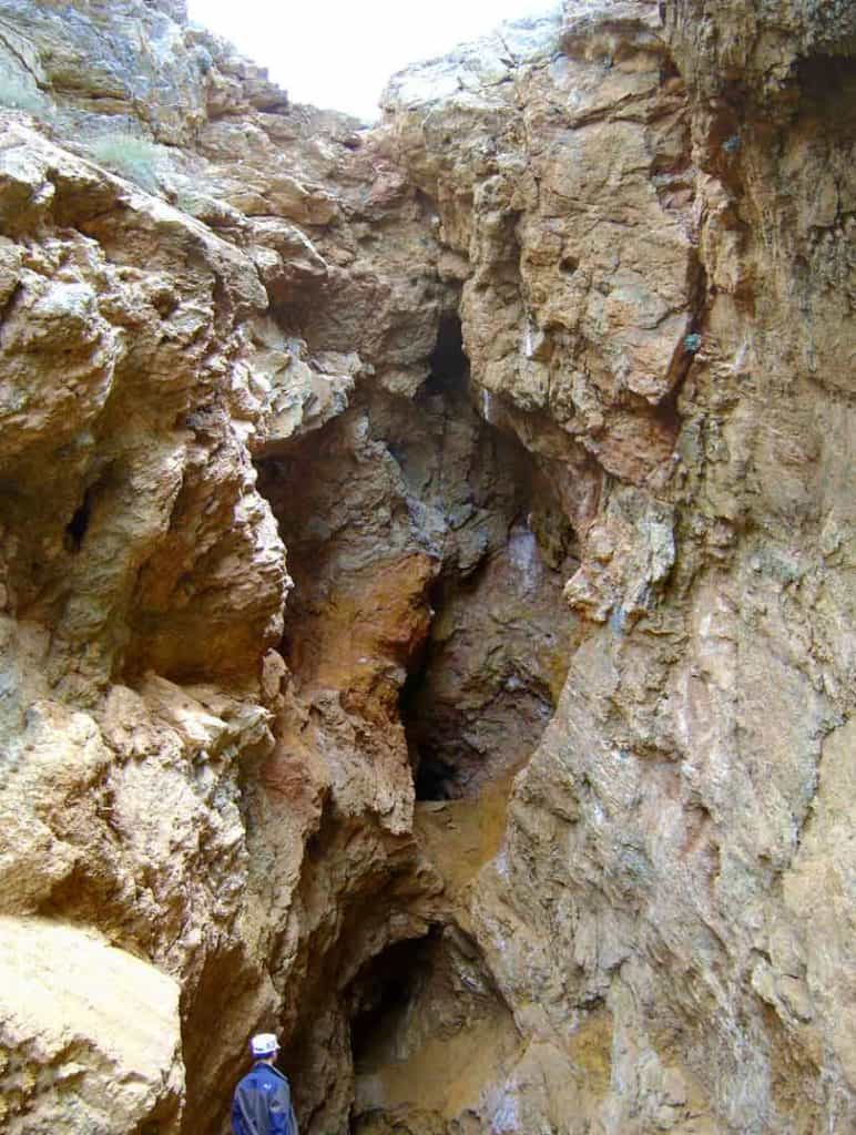 The fissure running up from the figure at the base to the top is a Roman lead-mining shaft, exposed on the edge of a recent mining pit. 
