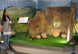 Adygian Museum guide with a porthole dolmen with paintings.