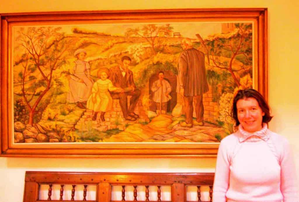 The maîtresse of ‘An Ti Gwenn’ standing in front of an image of her archaeologist grandfather at work.