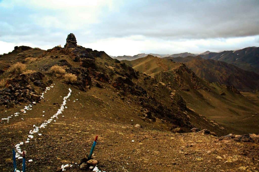 In the remote corner of Mongolia's southwest, within the restricted border zone, a white stone lined footpath leads up a ridge....